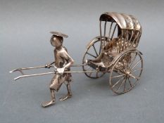 A Chinese white metal rickshaw with man pulling,