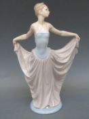 A Lladro figure of a girl holding her ballgown