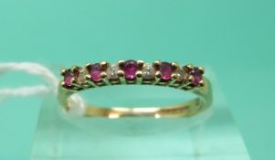 A 9ct gold ring set with alternating rubies and diamonds (Size L)