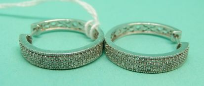 A pair of 9ct white gold hoop earrings set with diamonds.