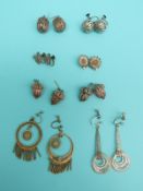 Eight pairs of white metal filigree earrings including flowers, spheres,