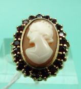A 9ct gold ring set with a cameo surrounded by garnets (Size L)