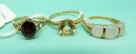Three 9ct gold rings, one set with a garnet,