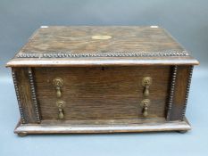 An early 20thC brass inlaid oak canteen with lift-up lid,
