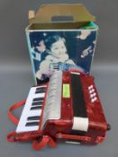 Child's piano accordion with eight bass buttons complete with box and tutor book