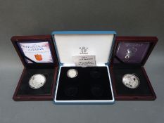 Two deluxe cased silver £5 proof coins together with a 2004 silver Piedfort £1 coin,
