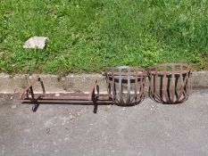 A pair of hay racks and a wall-mounted holder for a trough