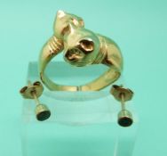 A yellow metal ring in the form of two cats and a pair of 9ct gold earrings set with an emerald to