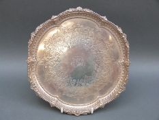 A Victorian hallmarked salver with shaped rim and engraved decoration,