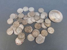 A 1923 Liberty dollar and a quantity of Victorian and later silver three pence pieces,
