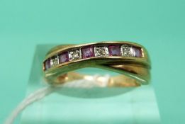 A 9ct gold ring set with alternating rubies and diamonds in a twist setting (Size L)