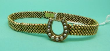 A late Victorian/ early Edwardian 15ct gold bracelet featuring a horse shoe set with seed pearls,