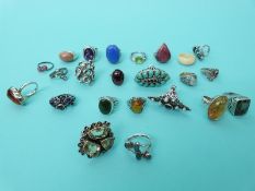 Twenty two silver/ white metal rings variously set with amber, smoky quartz,