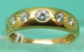 A yellow metal ring set with five graduating clear stones (Size L)