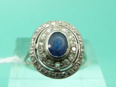 An Art Deco platinum ring set with a sapphire surrounded by two rows of diamonds (Size L)
