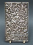 A white metal filigree plaque decorated with raised foliate and butterfly design with Chinese marks