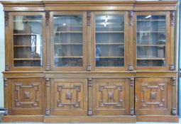 A Victorian Carolean style glazed breakfront bookcase with adjustable dogstooth shelving,
