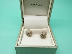 A pair of 9ct gold earrings set with diamonds in a cluster