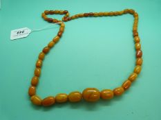 An amber necklace made up of graduated egg yolk coloured beads, 87g.