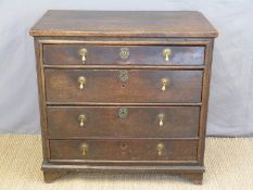 An antique oak chest of four straight graduated drawers raised on bracket feet,