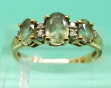 A 9ct gold ring set with green sapphires (Size L)
