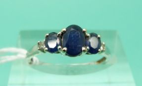 An 18ct white gold ring set with three oval sapphires and two diamonds (Size J)