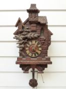 Early to mid twentieth century Black Forest carved cuckoo clock in the style of an alpine building,
