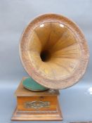 A vintage gramophone with embossed metal horn and decorative metal panel to front