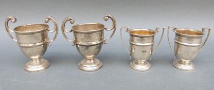 Two pairs of miniature twin handled trophy cups, height of larger 6.