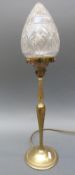 A brass lamp with a cut glass shade,