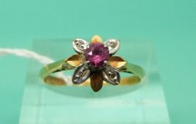 An 18ct gold ring set with a ruby and diamonds in a flower setting (Size O)