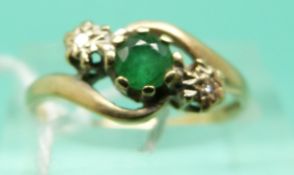A 9ct gold ring set with an emerald and two diamonds (Size M)