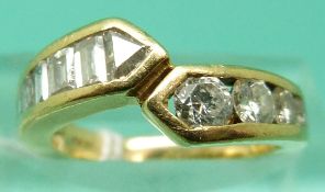 An 18ct gold ring set with five graduating round brilliant cut diamonds, two princess cut diamonds,