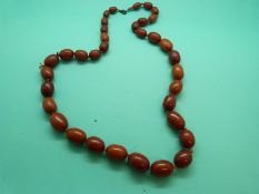 An amber necklace made up of oval graduated opaque beads,