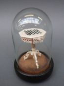 A 19thC intricately carved miniature games table with single drawer containing miniscule carved