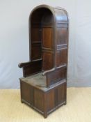 An antique oak peg jointed and panelled porter's chair with lift up compartment to seat H183 x W73
