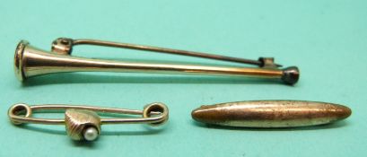 A gold brooch set with a pearl in the form of a shell and two other brooches