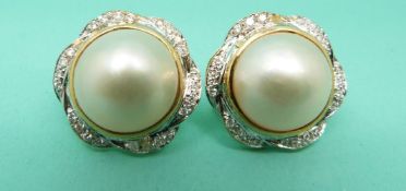 A pair of 18ct gold earrings each set with a Mabe cultured pearl surrounded by 24 brilliant cut