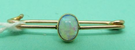 A gold brooch set with an opal cabochon