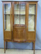 An Edwardian mahogany inlaid display cabinet with convex glazed central panel and concave cupboard