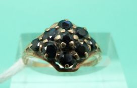 A 9ct gold ring set with sapphires in a cluster (Size L)