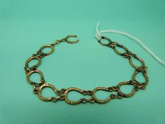 A yellow metal bracelet made up of horseshoe links, weight 9.