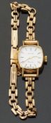 Avia ladies wristwatch with two tone hands and baton markers, on 9ct gold bracelet,