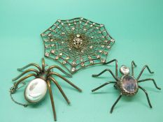 A brooch in the form of a spider's web set with paste and two spider brooches