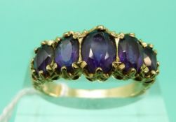 An Edwardian 9ct gold ring set with five graduated oval amethysts (Size N)