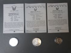 A 2002 USA silver eagle dollar, together with a 2003 example and a JFK 1964 half dollar,