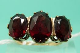 A 9ct gold ring set with three large garnets (Size N)
