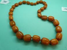 An amber necklace comprising 30 graduated barrel-shaped beads, 150g.