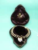 A yellow metal curb link bracelet marked 15ct with heart clasp in original Russells of Liverpool