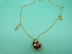 A yellow metal pendant in the form of a guilloche enamel egg set with clear paste on an 9ct gold